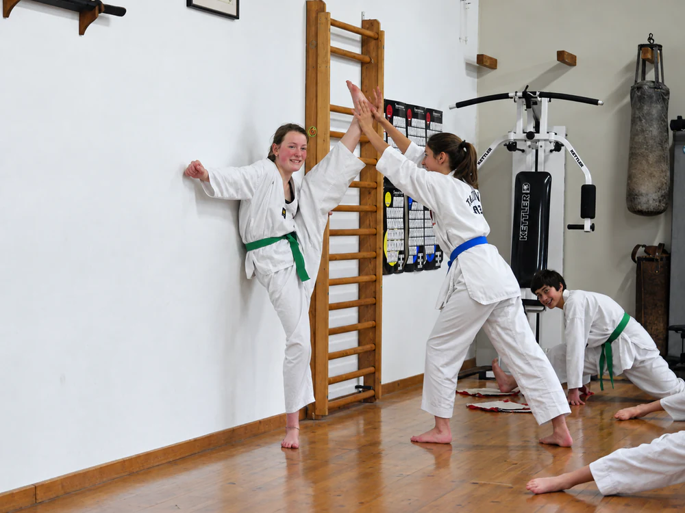 Élèves à l’échauffement dans la salle du dojo